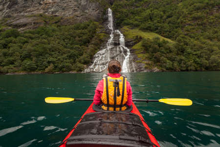 Little kayak in a lake or in a big river with a beautiful girl traveler on natural backgroundの写真素材