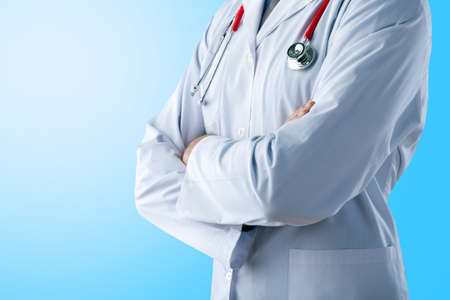 Young doctor shows stop sign with hands on abstract gradient backgroundの写真素材