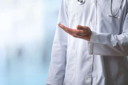 Young doctor shows open sign with hands on abstract gradient backgroundの写真素材