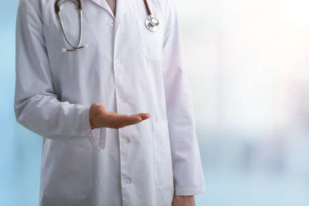Young doctor shows open sign with hands on abstract gradient backgroundの写真素材