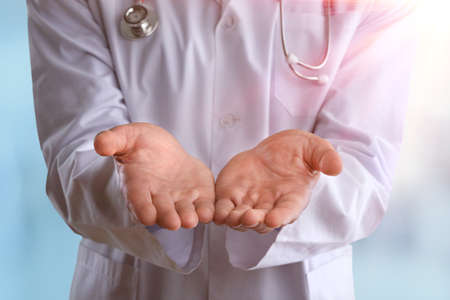 Young doctor with a stethoscope shows with his handsの写真素材