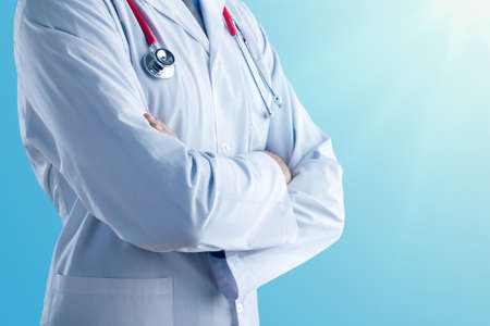 Young doctor with a stethoscope shows stop sign with his handsの写真素材