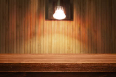 Wooden desk on bokeh blur abstract light backgroundの写真素材