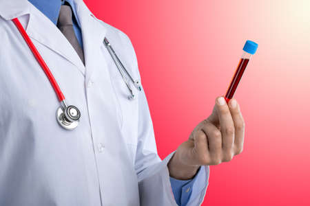 Young doctor with a stethoscope shows tube with blood or plant on pastel gradien backgroundの写真素材
