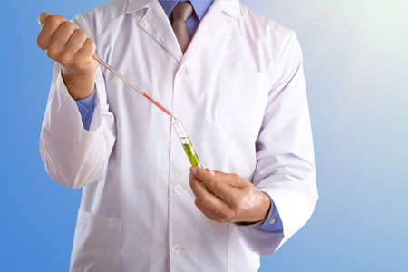 Young doctor with a stethoscope shows tube with blood or plant on pastel gradien backgroundの写真素材