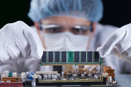 Scientist working with a computer motherboard, technology conceptの写真素材
