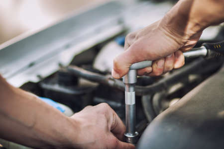 Man master repairs under the hood of the car. Repairing concept