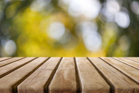 Wooden desk on autumn blur natural backgroundの写真素材