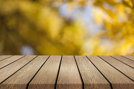 Wooden desk on autumn blur natural backgroundの写真素材