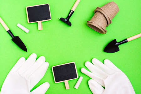 Home gardening. Miniature gardening tools: a scoop, a rake, a writing board, gloves and chalk are...