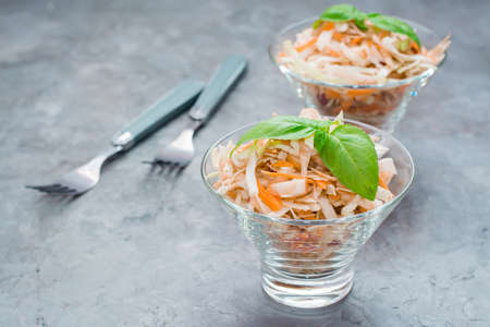 American ready-to-eat cole slaw salad of cabbage, celery, carrots and apples with basil leaves in...