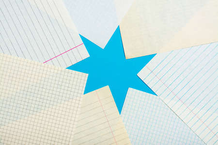 Many clean copybook sheets in a cell and line form a star shape on a blue background. Top view
