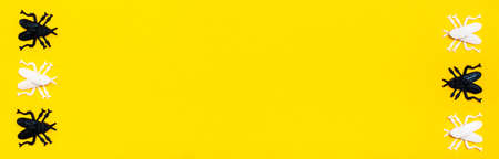 Ready web banner for halloween. White and black plastic flies on a yellow cardboard background. Copy...