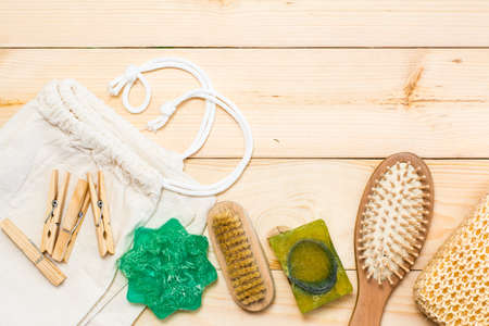 Zero waste bathroom accessories, natural sisal brush, wooden comb, solid soap, canvas bag and wooden clothespins on a natural wooden background. Top viewの写真素材
