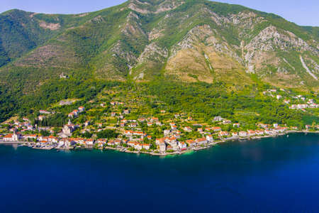 Montenegro. Adriatic Sea. Bay of Kotor. popular tourist spot. Village on the coast. Houses with orange tiled roofs. Summer. tourist season. drone. Aerial viewの写真素材