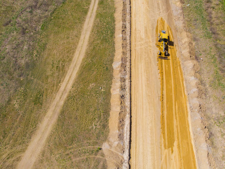 countryside. Spring. Sunny day. Construction machinery makes a new road in the field. drone. air viewの写真素材