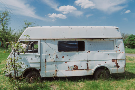 An old bus in the countryside, damaged by artillery fire. War in Ukraine. Russian invasion of Ukraine. Terror of the civilian population. war crimesの写真素材