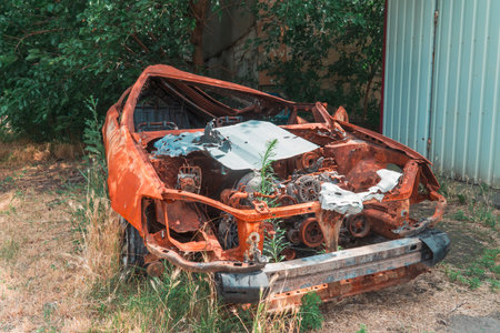 On the side of the road is a wrecked, burned-out civilian car. War in Ukraine. Russian invasion of Ukraine. war crimesの写真素材