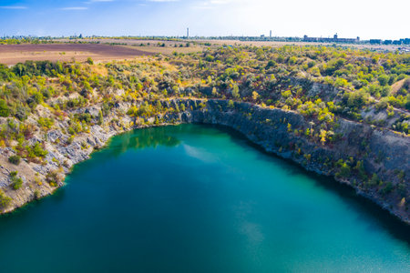 Flooded and abandoned granite quarry with clear turquoise water. Sunny autumn day. Drone. Aerial viewの写真素材