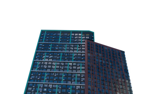 Two tall, modern residential apartment buildings with dark, contrasting facades isolated on a clean white background, viewed from a low angleの写真素材