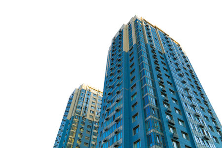 Two contemporary blue glass skyscrapers isolated on a white background, captured with a low angle view to emphasize height and modern architectureの写真素材