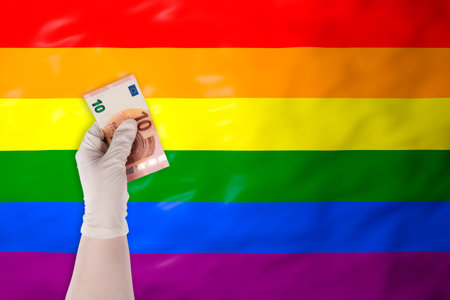 Sad girl wrapped in a warm blanket by a radiator with a candle during a power outage at night. Concept of energy crisis and cold winterの写真素材