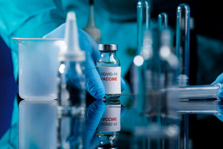 Coronavirus vaccine concept. Doctor in blue gloves holding ampoule with COVID-19 vaccine.