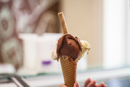 Chocolate ice cream in a waffle cone on a blurred backgroundの写真素材