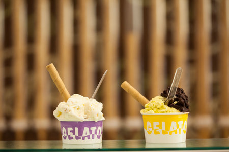 Ice cream scoops with wafer sticks on a glass table.の写真素材