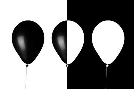 isolated Inflatable light flying balloons in black and white on opposite backgrounds. Shows equality between the races of people, that we are all equal, even if we are all different in colorの写真素材