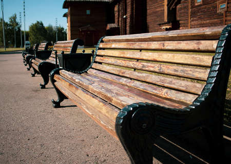 A bench made of metal and wood stands in the parkの写真素材