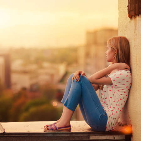 beautiful blonde sitting on the roof of the house beautiful blonde sitting on the roof of the house