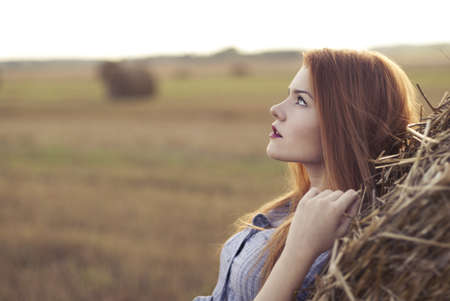 portrait of a beautiful red-haired girl in a fieldの写真素材
