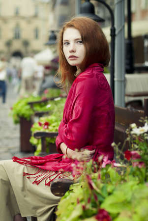 beautiful redheaded woman resting on the streets of the beautiful cityの写真素材
