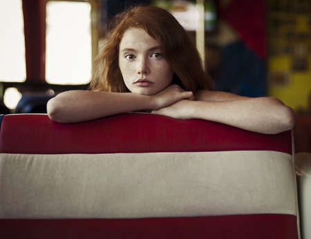 beautiful redheaded woman relaxing in a cafeの写真素材