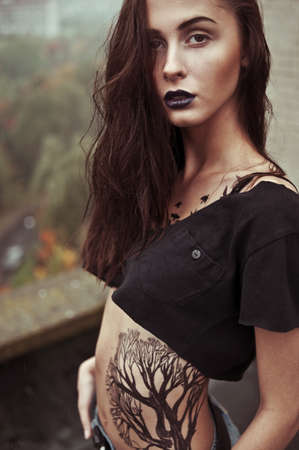 beautiful girl with a tattoo on the roofの写真素材