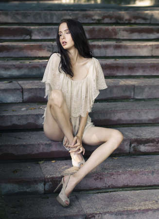 beautiful girl on the sadness of old stairsの写真素材