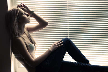beautiful girl at the window sadの写真素材