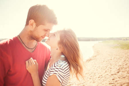 beautiful couple kissing on the beach on a sunny morningの写真素材