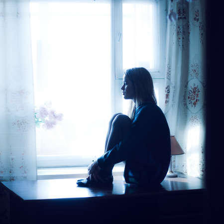 sad beautiful girl at home tonight の写真素材