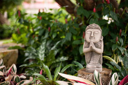 Statue of prayer in tropical gardenの写真素材