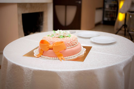 Wedding orange cake with ribbon on the tableの写真素材