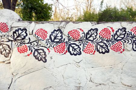 Petrykivka traditional ukrainian painting on the white stone fence. The fence on island Khortytsia in ukrainian city Zaporizhia.の写真素材