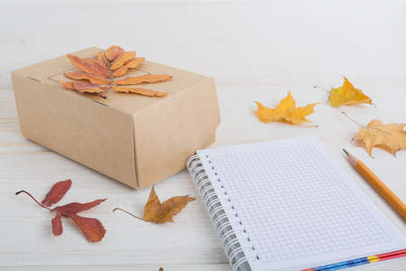  craft paper box, notebook, pencil decorate autumn leaves. autumn business concept.の写真素材