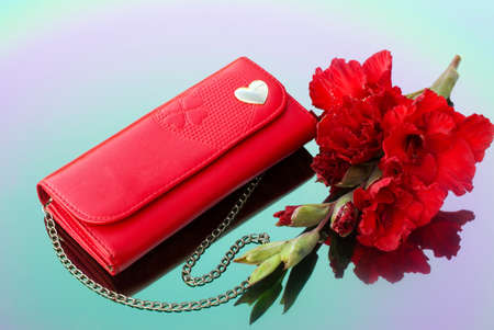 Red purse with chain and red gladiolusの写真素材