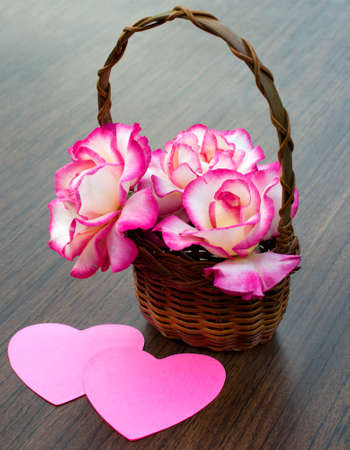 bouquet of roses is in a wicker basket and two heartsの写真素材