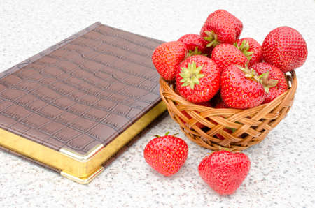 leather-bound book and ripe red strawberriesの写真素材