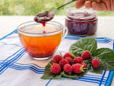 tea with raspberry jam and fresh raspberries