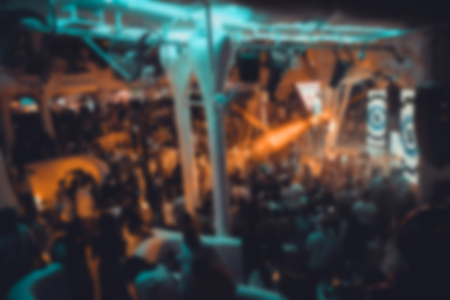 Blurry night club dj party people enjoy of music dancing sound with colorful light. club night light...