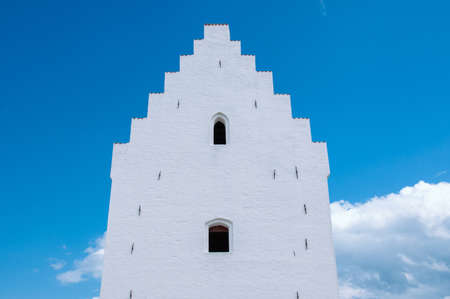 The facade of the white church ovet the background of the blue sky. Sanded Church, Skagen, Denmark.の写真素材